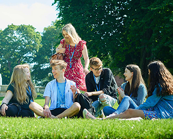 students sitting on grass in park