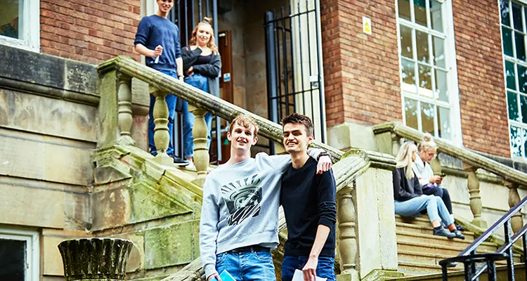 Six A Level students standing and sitting on the steps at English Bridge Campus