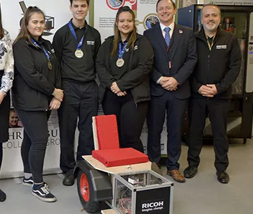 Students and staff in front of engineering project