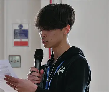 Close up of student holding microphone asking questions