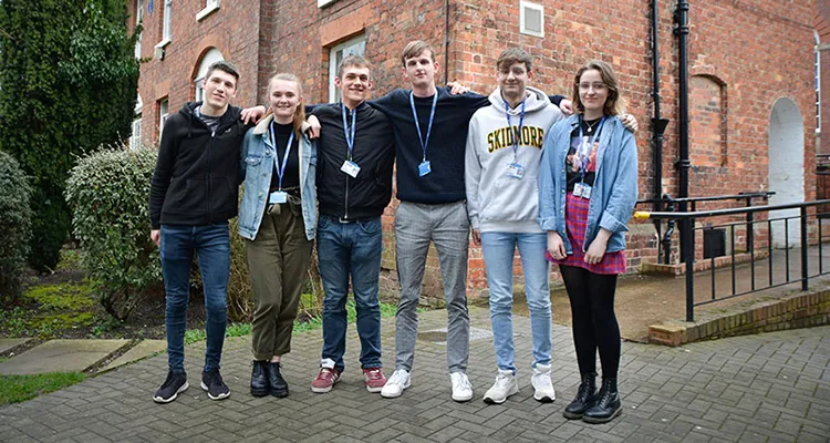 Students standing in a row outside college campus