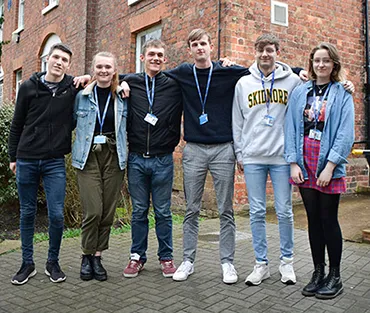 Students standing in a row outside college campus