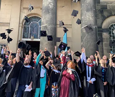 Graduation students throwing their cap outside St Chads