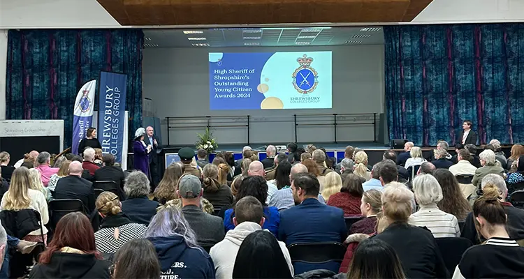 A hall full of people looking at stage