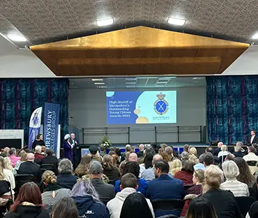 A hall full of people looking at stage