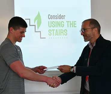 Student shaking hands and receiving certificate from employer