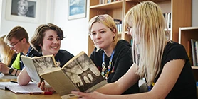 Three students reading books together 