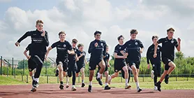 Sport students running side by side on running track