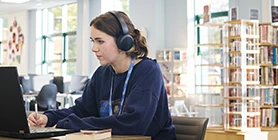 Student with laptop in library